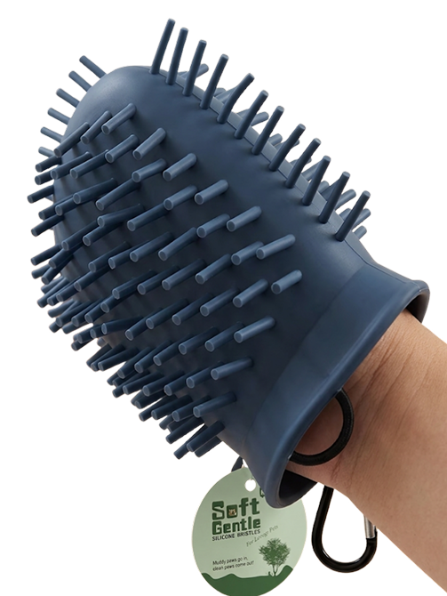 Blue pet grooming brush held by a hand with a visible brand tag on a white background