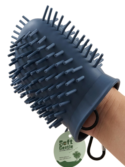 Blue pet grooming brush held by a hand with a visible brand tag on a white background